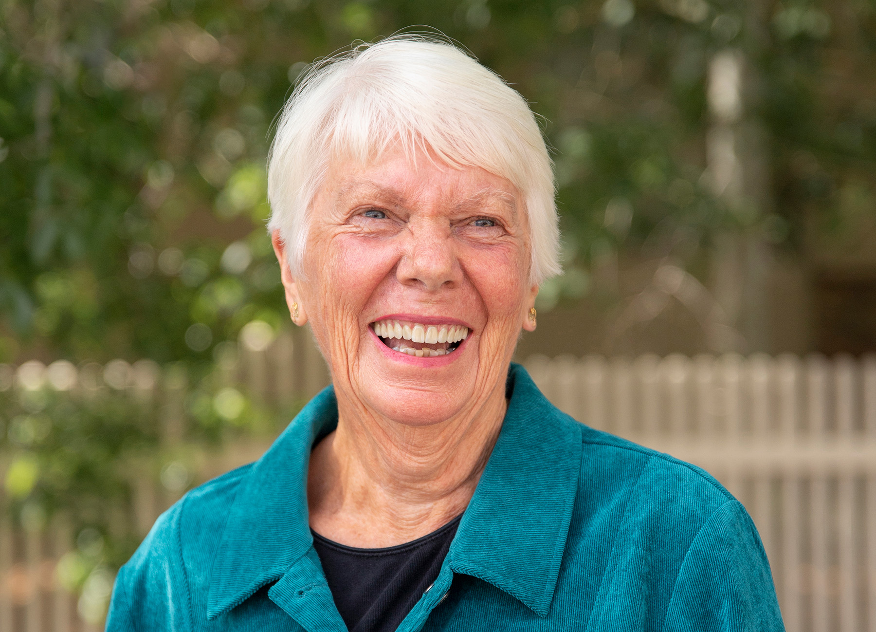 Wyo Dental Implants patient with white hair laughing outdoors
